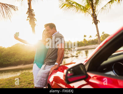 Coppia caucasica tenendo selfie su cabriolet Foto Stock