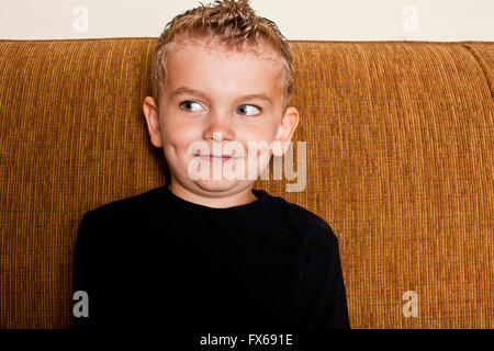 Caucasian ragazzo seduto sul divano Foto Stock