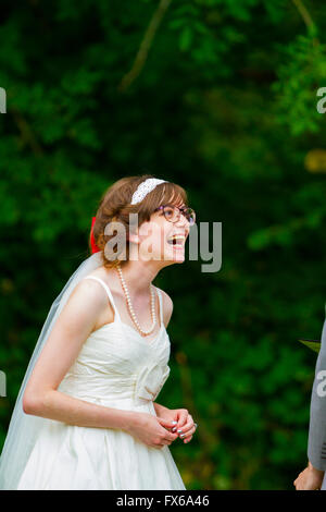 Sposa ridendo durante la sua cerimonia nuziale dopo lo sposo ha detto qualcosa di divertente. Foto Stock