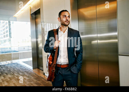 Imprenditore caucasico in attesa per office ascensore Foto Stock