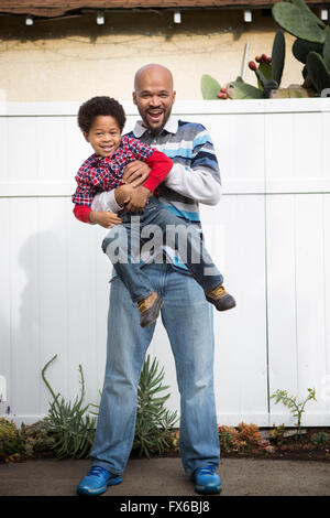 Razza mista padre figlio di contenimento esterno Foto Stock
