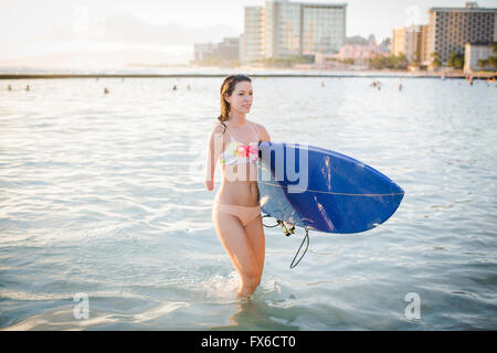 Razza mista amputato che trasportano le tavole da surf in ocean Foto Stock