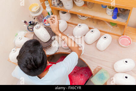 Artista di origine ispanica pittura vasi in studio Foto Stock