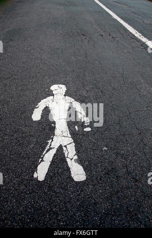 Dipinto di bianco di corsia pedonale figura su asfalto screpolato Foto Stock