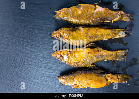 Vista dall'alto di fritto tinca pesce servite su sfondo di ardesia, close up Foto Stock