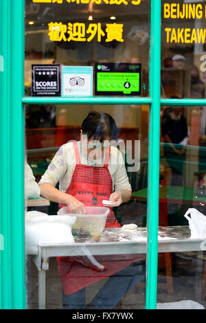 Anziana signora cinese il riempimento di pasticcini a China Town, Soho, Londra Foto Stock