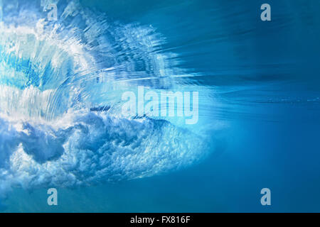 Foto subacquee di oceano onda estreme che si infrangono sulla spiaggia tropicale con spray, schiuma, increspature sulla superficie dell' acqua e pattern di bolle Foto Stock