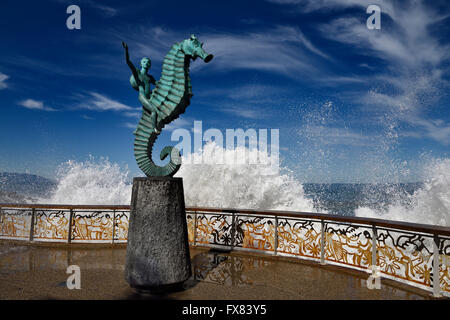 Il ragazzo su un cavalluccio scultura Puerto Vallarta malecon con schizzi di oceano pacifico messico acqua Foto Stock