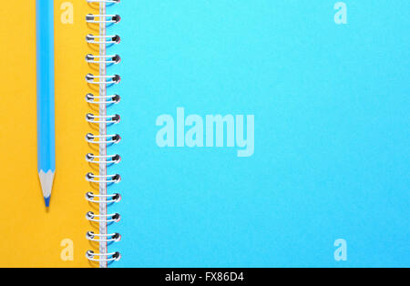 Matita blu su notebook con colorato pagine vuote Foto Stock
