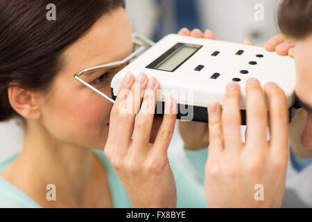 Ottico con pupillometro e paziente alla clinica oculistica Foto Stock