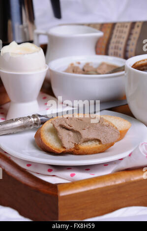 Una fetta di pane tostato spalmato con patè di fegato per la colazione su un vassoio Foto Stock