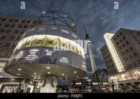Berlin Alexander Square, Orologio mondiale, la torre della TV Alex, tram in background,twilight Foto Stock