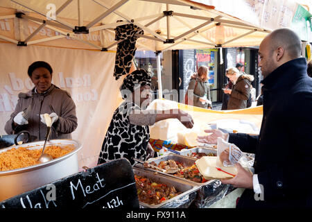 Persone che acquistano alimenti, Brick Lane domenica sistemazione, Brick Lane, Spitalfields, East End, London REGNO UNITO Foto Stock