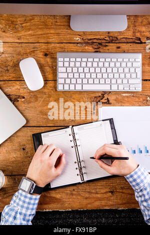 Imprenditore iscritto nell'agenda elettronica personale, indossando smart watch Foto Stock