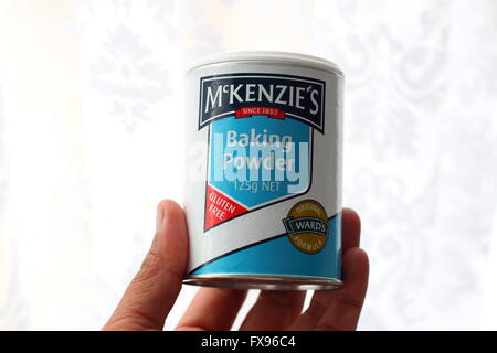 Chiudere l immagine della mano sinistra tenendo McKenzie il lievito in polvere su sfondo bianco Foto Stock