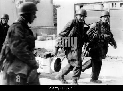 La foto della propaganda nazista mostra i membri del battaglione SS-Parachute del 500th con munizioni durante la conquista della città di Drvar in Jugoslavia. La foto è stata scattata a fine maggio/inizio giugno 1944. L'obiettivo della cosiddetta 'operazione Roesselsprung' era la distruzione della sede superiore dei partigiani jugoslavi e la cattura del suo leader Josip Broz Tito. Fotoarchiv für Zeitgeschichtee - SENZA FILI - Foto Stock