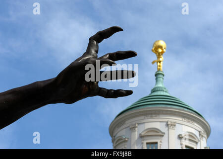 Potsdam, Germania. Xiii Apr, 2016. Il raggiungimento fuori artiglio del uno 63 sculture intitolata 'Wolfsmenschen' (lit. Wolf persone) dall artista Rainer Opolka sono sul display davanti alla storica chiesa di San Nicola (l) e il vecchio municipio presso la Alte Markt square a Potsdam, Germania, 13 aprile 2016. " Il pacco di lupi stand simbolicamente per 'odio la gente, tubi espulsori di arson, Neonazis, adirato contro i sostenitori di Pegida AfD e che vogliono sparare ai rifugiati', Opolka ha spiegato le sue opere d'arte. Le sue sculture sono state precedentemente sul display alla chiesa Frauenkirche di Dresda. Foto: Ralf Hirschberger/dpa/Alamy Live News Foto Stock