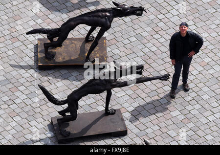 Potsdam, Germania. Xiii Apr, 2016. Artista Rainer Opolka sorge di fronte a due dei suoi 63 sculture intitolata 'Wolfsmenschen' (lit. Wolf persone) presso la Alte Markt square a Potsdam, Germania, 13 aprile 2016. " Il pacco di lupi stand simbolicamente per 'odio la gente, tubi espulsori di arson, Neonazis, adirato contro i sostenitori di Pegida AfD e che vogliono sparare ai rifugiati', Opolka ha spiegato le sue opere d'arte. Le sue sculture sono state precedentemente sul display alla chiesa Frauenkirche di Dresda. Foto: Ralf Hirschberger/dpa/Alamy Live News Foto Stock