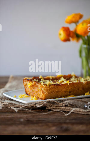 Limone e olio di oliva la torta su una piastra bianca e rustico tavolo in legno Foto Stock