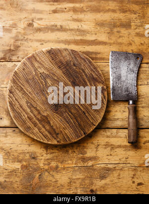 Butcher carne cleaver e tagliere blocco su sfondo di legno Foto Stock