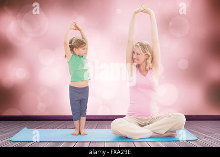 Immagine composita della gravidanza sorridente madre e figlia fare yoga insieme Foto Stock