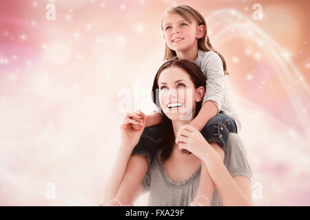 Immagine composita di allegro madre dando piggyback ride a sua figlia Foto Stock