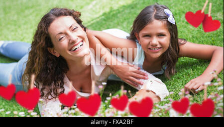 Immagine composita della madre e figlia giacente sull'erba Foto Stock