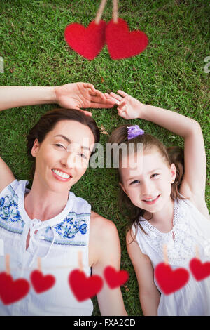 Immagine composita della madre e figlia giacente sull'erba Foto Stock