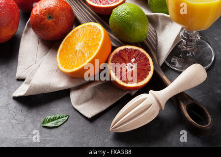 Fresche e mature agrumi. I Limoni e limette e le arance in pietra scura sullo sfondo Foto Stock