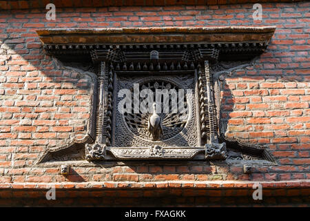 Scolpiti in legno finestra Pavone in una casa, Bhaktapur, Kathmandu, Nepal Foto Stock