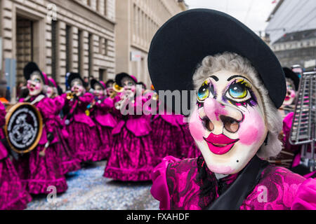 Membri della Gugge Marching Band di ottone che indossa abiti a fantasia e le maschere per la grande processione al Carnevale di Basilea Foto Stock