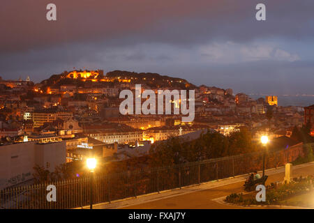 Vista dal Miradouro di Sao Pedro de Alcantara sul Alfama, Baixa e Castelo Sao Jorge distretti al crepuscolo, Lisbona, Portogallo Foto Stock