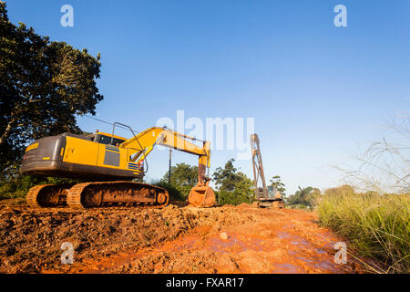 Lavori di sterramento costruzione pesante macchina escavatore bin e mobile gru rigging sul sito Foto Stock