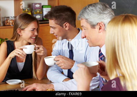 Quattro sorridente la gente di affari di prendere una pausa con un caffè in una caffetteria Foto Stock