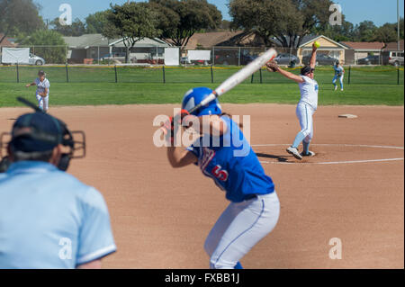 Softball player in bianco uniforme garantendo il passo dal cerchio. Foto Stock