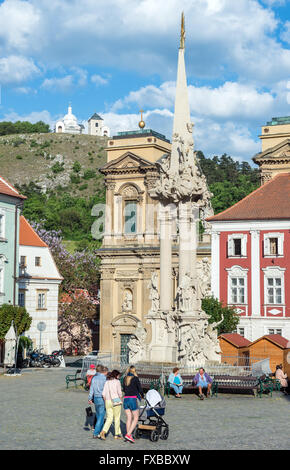 Santa Trinità statua (Colonna della Peste) a piazza centrale in Mikulov, Repubblica Ceca. Dietrichstein tomba di famiglia sullo sfondo Foto Stock