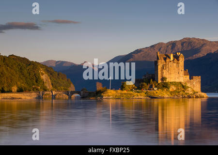 Impostazione della luce solare sullo Eilean Donan Castle lungo il Loch Duich, Dornie, altopiani, Scozia Foto Stock