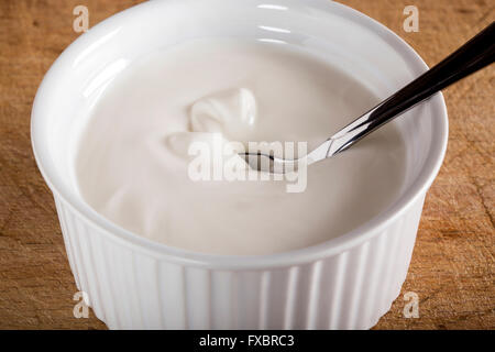 Panna acida in bianco ciotola con cucchiaio Foto Stock