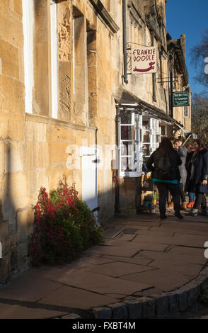 Un gruppo di giovani turisti femmina window shopping nella parte superiore della strada di Chipping Campden in dicembre, Cotswolds, Gloucestershire, Inghilterra Foto Stock
