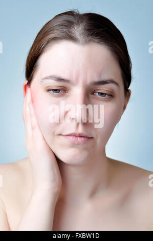 Giovane donna di toccare il suo orecchio infiammato Foto Stock
