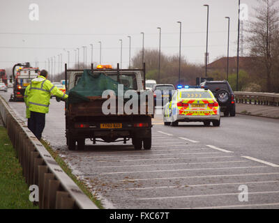 Newcastle Upon Tyne, Regno Unito. Il 14 aprile 2016. Fermo Northumbria auto della polizia del traffico di alimentazione passato un veicolo multi car crash sul 1058-coast road in North Tyneside precedentemente questa mattina come pulire gli equipaggi rendono il carrello modo risparmiate per gli automobilisti mediante la rimozione di detriti e levigazione qualsiasi fuoriuscita dai veicoli coinvolti nell'incidente. Credito: James Walsh Alamy/Live News Foto Stock