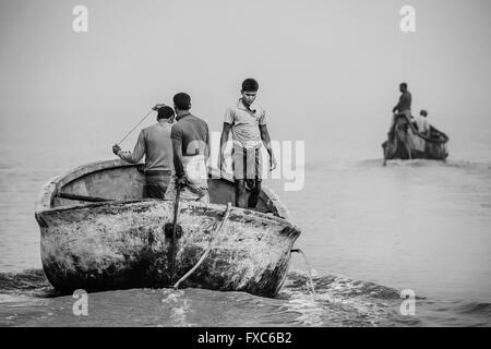 I pescatori in una barca partendo all'alba per il loro spot fishig tra le navi di luoghi di Chittagong in Bangladesh. Ogni mattina, i pescatori in Chittagong andare con le loro barche da pesca contaminati spots nel mezzo di una delle più grandi navi di luoghi di tutto il mondo. Foto Stock