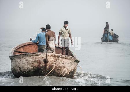 I pescatori in una barca partendo all'alba per il loro spot fishig tra le navi di luoghi di Chittagong in Bangladesh. Ogni mattina, i pescatori in Chittagong andare con le loro barche da pesca contaminati spots nel mezzo di una delle più grandi navi di luoghi di tutto il mondo. Foto Stock