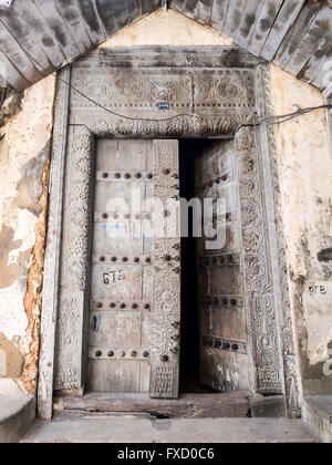 Foto verticale di vecchio di legno intagliate tradizionalmente porta in Stone Town Zanzibar, Tanzania Africa Orientale. Foto Stock