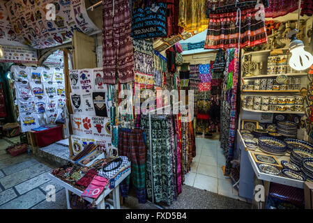 I vestiti e i negozi di souvenir al mercato arabo che scompostamente tra cristiani e musulmani quarti sulla Città Vecchia di Gerusalemme, Israele Foto Stock