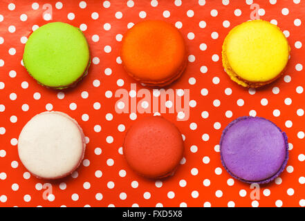 Sei macarons posa su red polka-dot vassoio Foto Stock