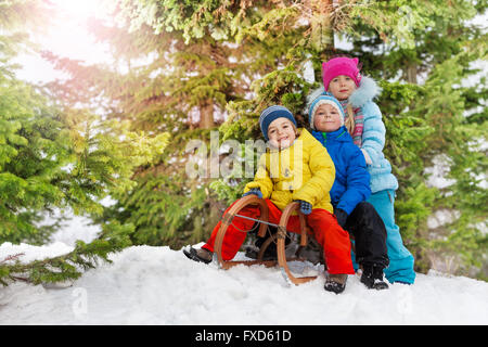 Bambini piccoli e divertimento invernale sulla slitta in posizione di parcheggio Foto Stock