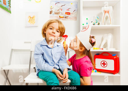 Carino dell'orecchio, del naso o della gola specialista esaminando boy Foto Stock