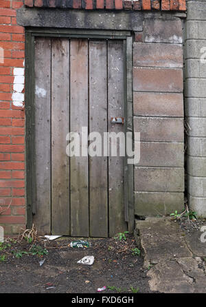 Il vecchio ben utilizzati e trasandato porta nella parete, per il miglior uso come una texture o dello sfondo. Cardiff Wales, Aprile 2016 Foto Stock