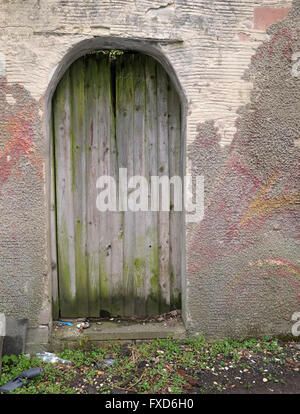 Il vecchio ben utilizzati e trasandato porta nella parete, per il miglior uso come una texture o dello sfondo. Cardiff Wales, Aprile 2016 Foto Stock